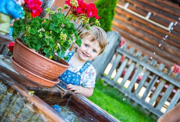 Kleines Mädchen am Garten des Bauernhauses
