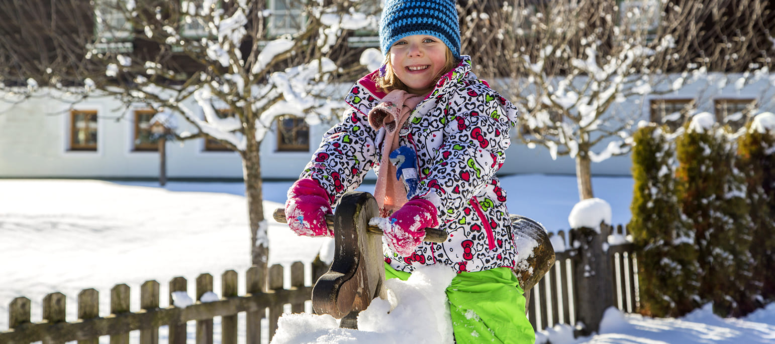 Kind auf dem Bauernhof im Winter